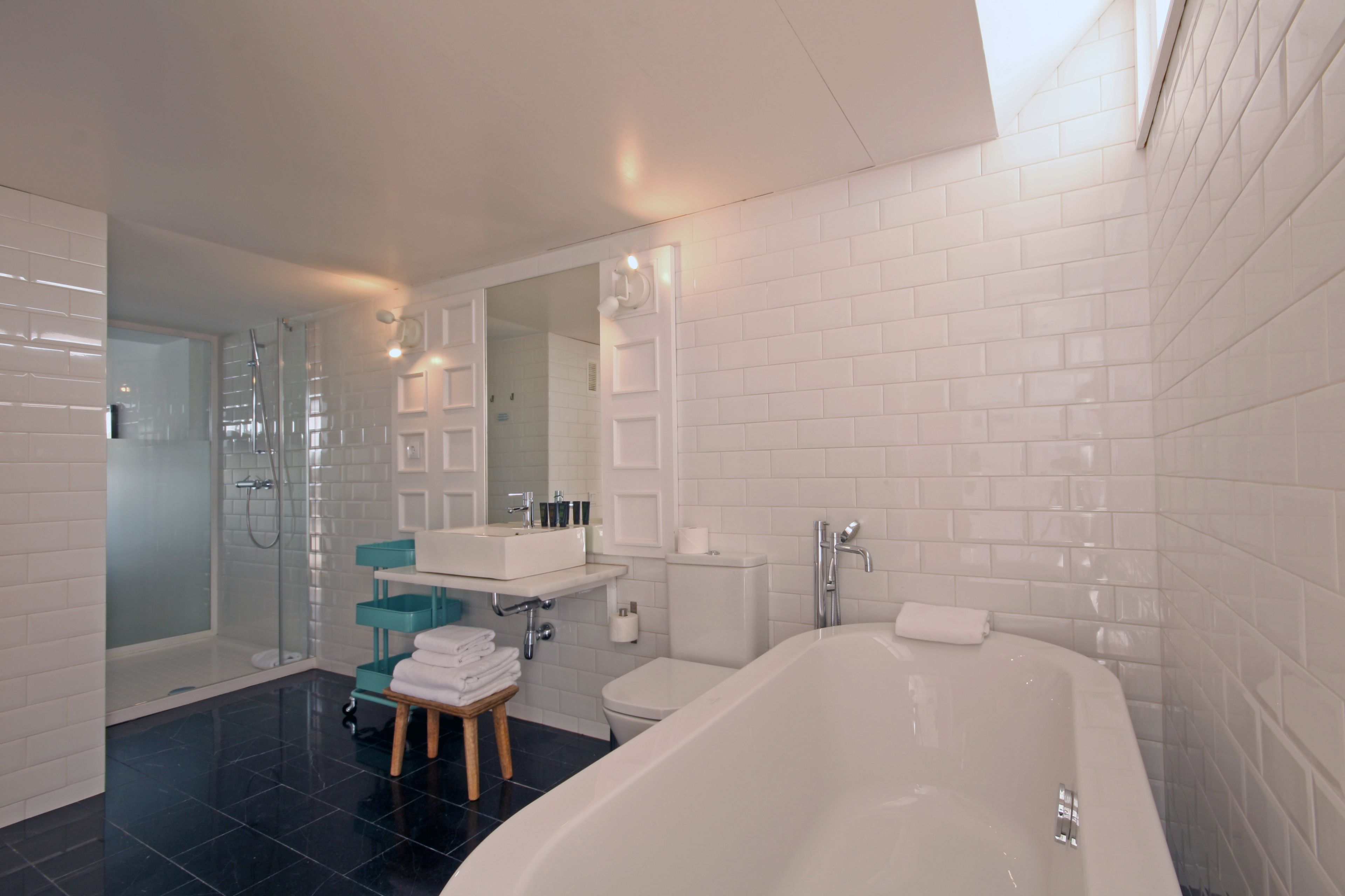 A modern bathroom with a large bathtub, a glass shower enclosure, and a vanity with a mirror.