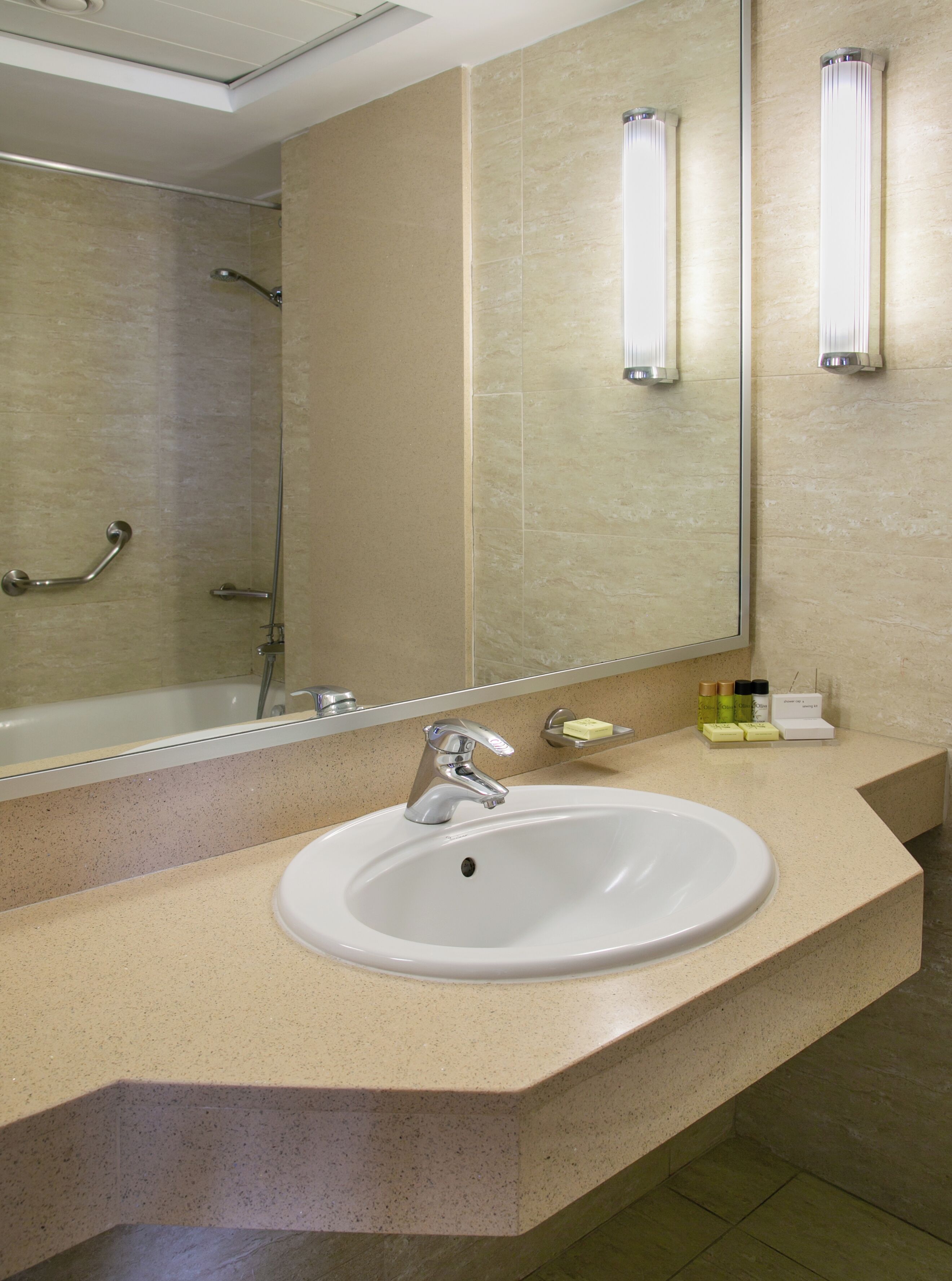 A bathroom with a white sink, a mirror, and a shower.