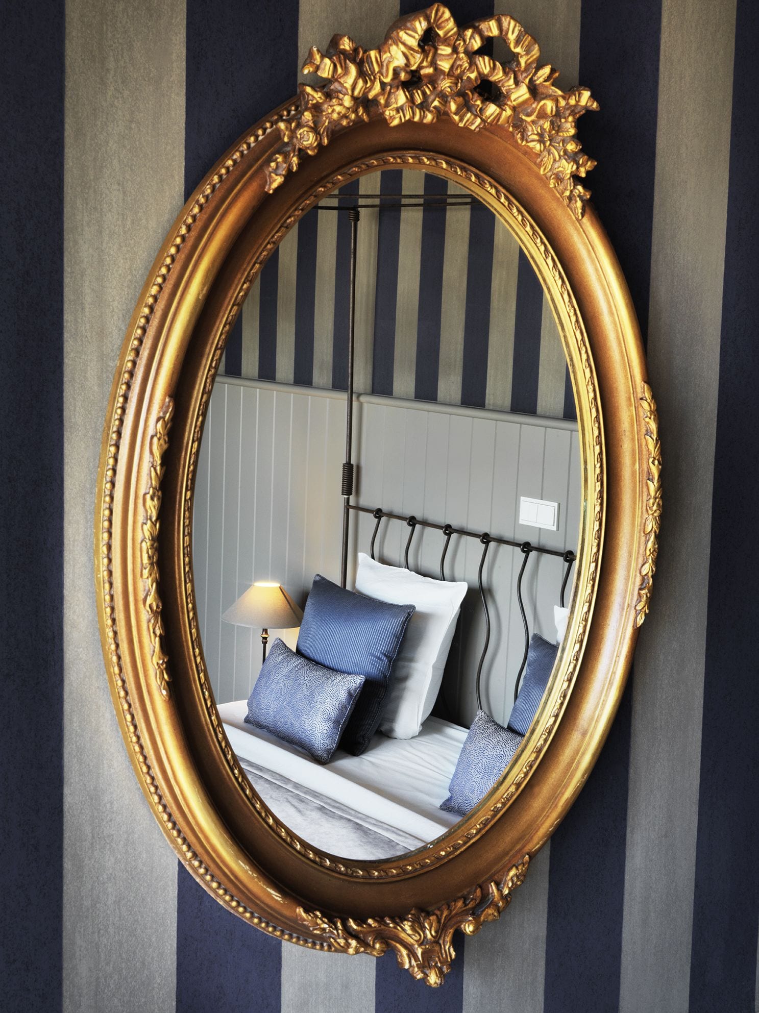 Un dormitorio con cama, almohadas y mesita de noche.
