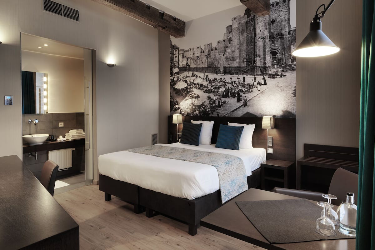 Una habitación de hotel moderna con una cama grande, un escritorio y una zona de comedor.