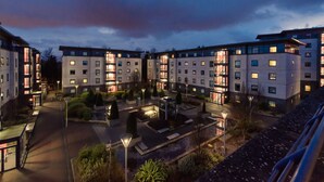 Un moderno complejo hotelero con varias edificaciones, un patio central y senderos bien iluminados.