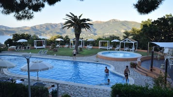 Relax by the serene pool surrounded by lush greenery and breathtaking mountain views.