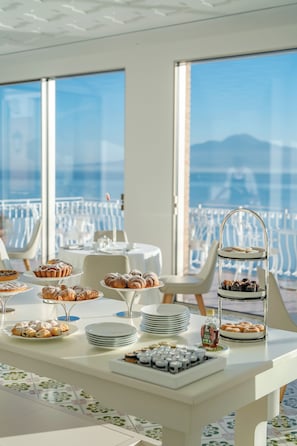 Enjoy a meal with a view of the surrounding mountains from this dining area featuring a buffet setup and large windows.