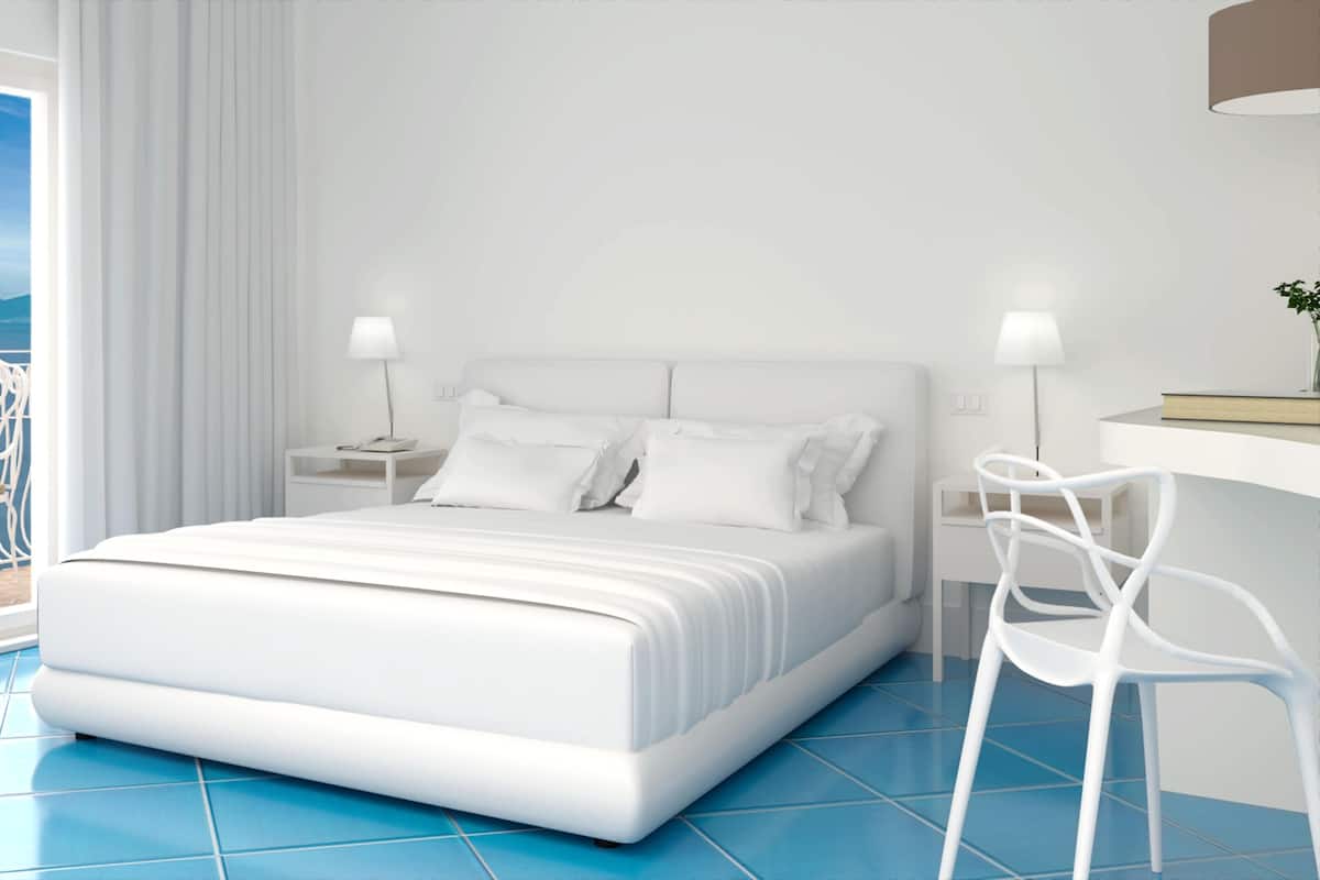 Una camera da letto moderna con un letto grande, comodini bianchi, una scrivania e una sedia.