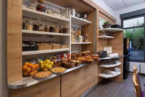 A café with shelves stocked with jars of fruits, cereals, and coffee, along with baskets of pastries and a display of mugs. - Apparthôtel Privilodges Lyon (Lyon)