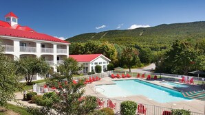 A hotel with a swimming pool, red-roofed building, and a mountainous backdrop. - Bluegreen Vacations South Mountain, an Ascend Collection Resort (Lincoln)