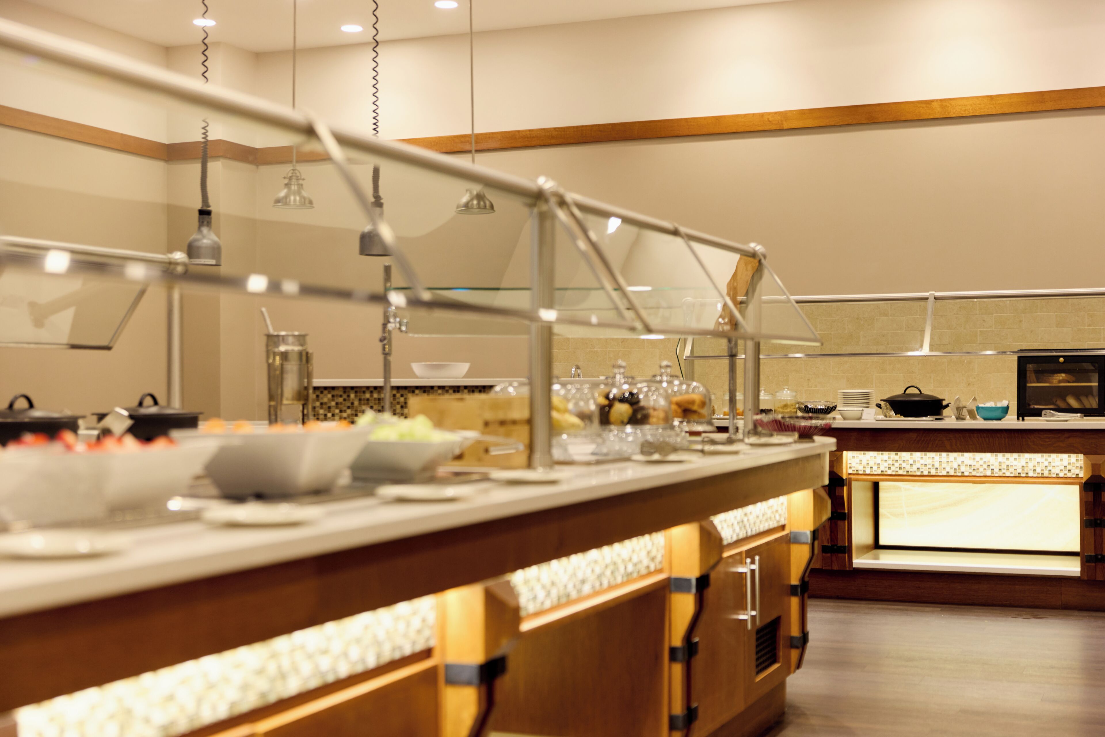 A buffet setup with a variety of food items and a counter with a glass display case.