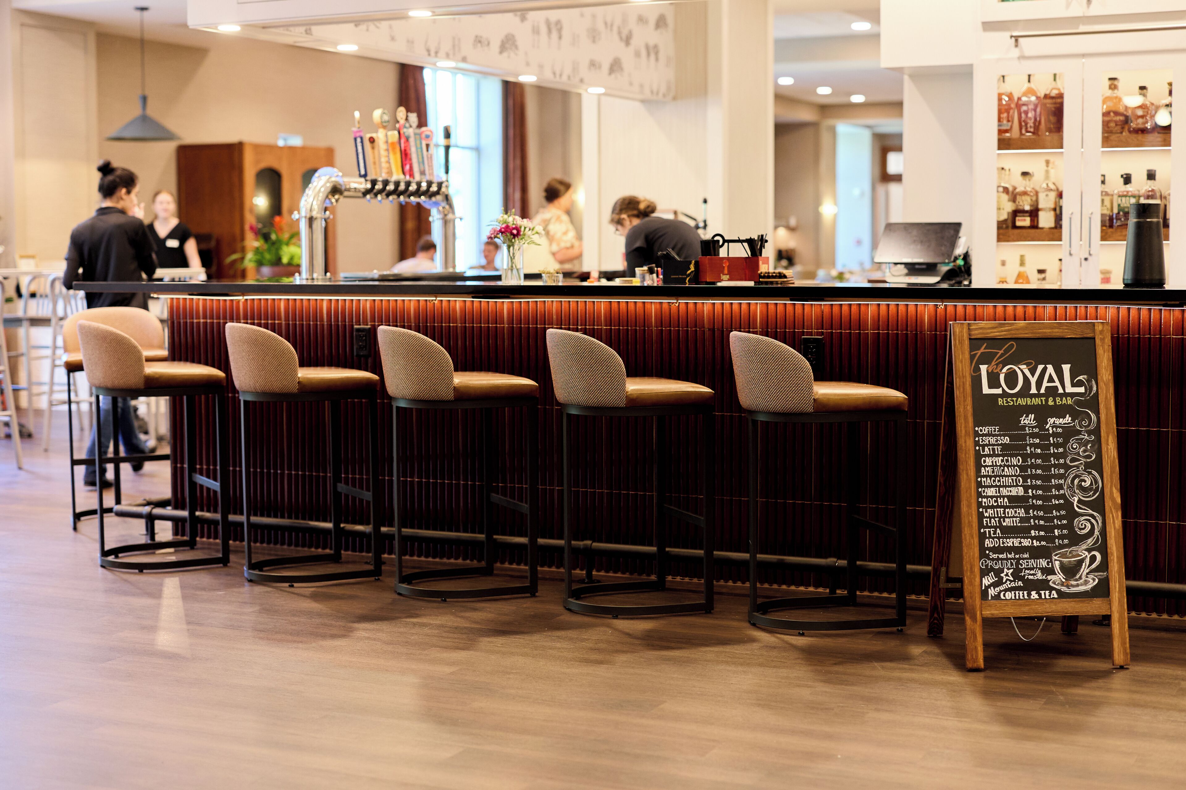 A bar area with stools, a chalkboard menu, and a bar counter.