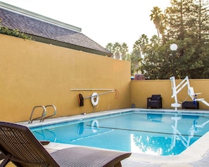 A swimming pool with lounge chairs, a lifebuoy, and a pool ladder. - Rodeway Inn (Martinez)