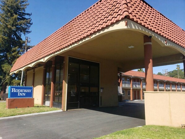 A Rodeway Inn with a covered entrance, large windows, and a signboard.