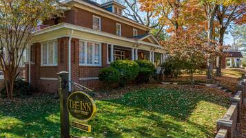 A two-story brick building with a front porch and a sign that reads "The Inn on Front Street."