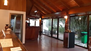 A spacious indoor area with a wooden ceiling and large windows. - Hotel Samara Beach (Sámara)