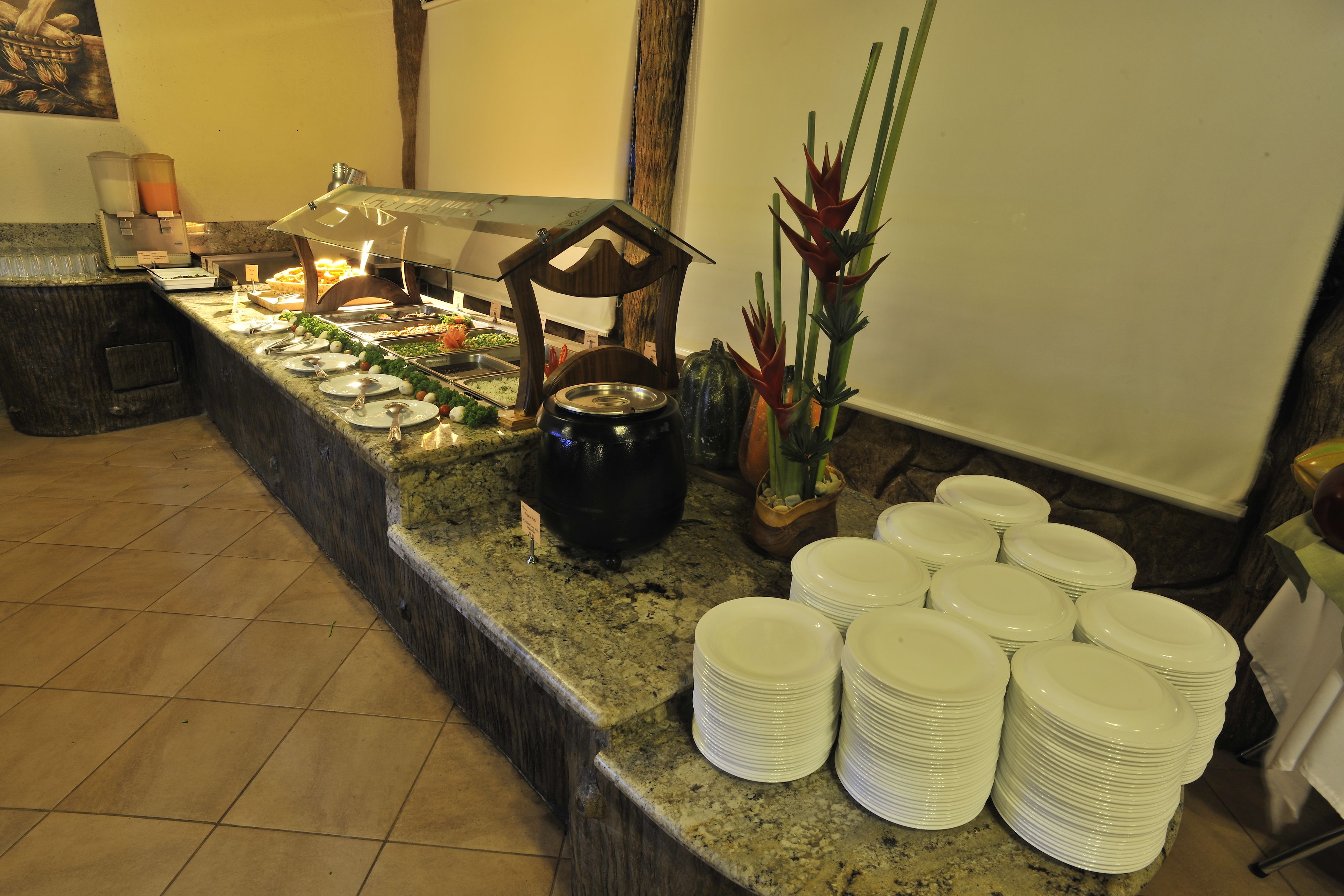 A buffet setup with various food items and a large pot of soup.