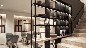 Un interior moderno con una escalera, una zona de comedor con sillas y una mesa, y un estante con objetos decorativos.