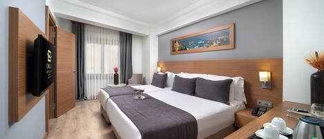 A hotel room with a large bed, bedside tables, a flat-screen TV, a cityscape painting, and a view of the city through the window.