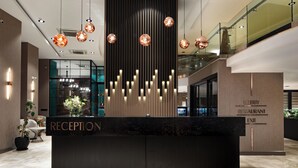 A reception desk with a modern design, featuring a black countertop and vertical light fixtures. - Orka Royal Hotel & Spa (Istanbul)