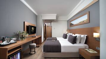 Une chambre d’hôtel équipée d’un lit, d’une table de chevet, d’une télévision, d’un bureau et d’un réfrigérateur.