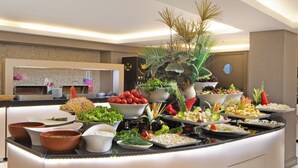A buffet with various dishes and a decorative plant. - Orka Royal Hotel & Spa (Istanbul)
