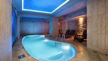 Een binnenzwembad, een buitenzwembad en ligstoelen