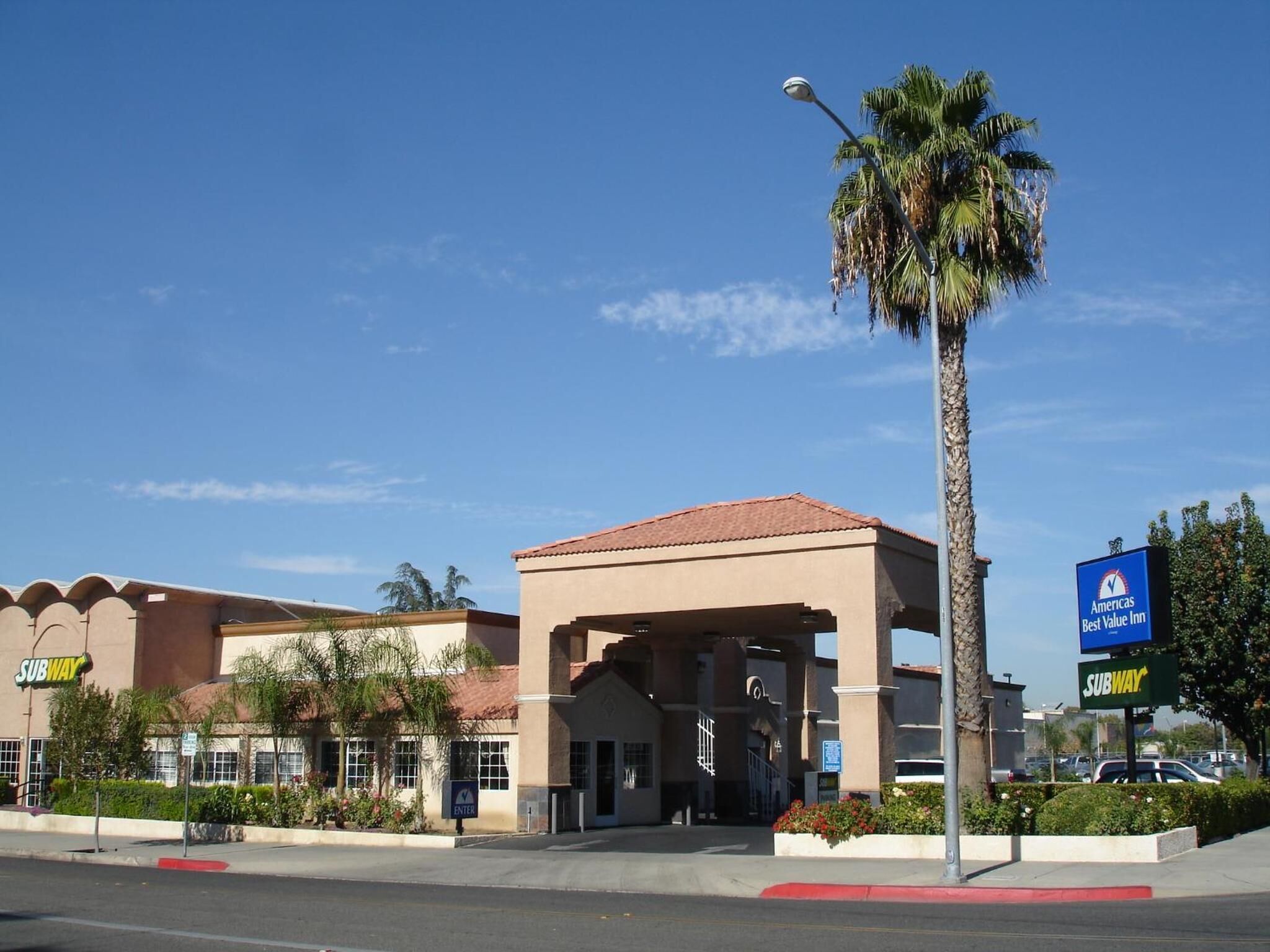 A building with a red-tiled roof, a Subway entrance, and a sign for Americas Best Value Inn.