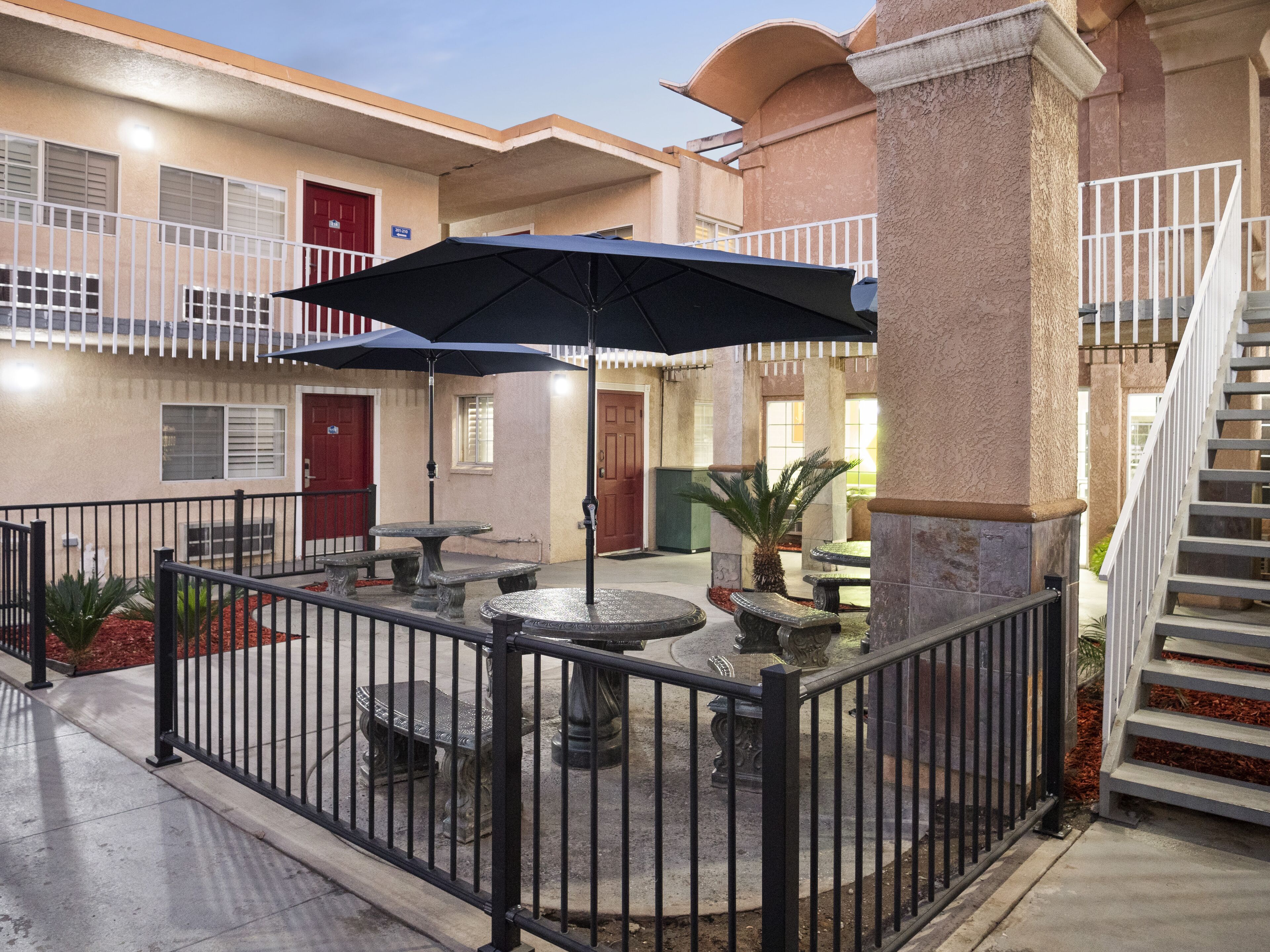 A courtyard with outdoor seating, a staircase, and a building facade.