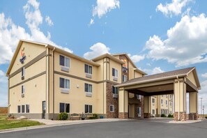 A multi-story hotel with a beige exterior, stone accents, and a covered entrance.