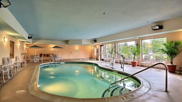 Een binnenzwembad, ligstoelen bij het zwembad