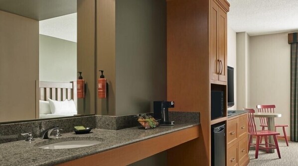 A hotel bathroom with a sink, mirror, and toiletries. - Great Wolf Lodge Bloomington (Bloomington)
