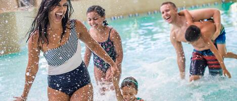 A swimming pool with people enjoying the water.