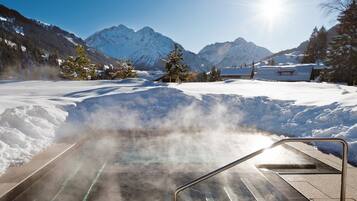 A snow-covered landscape with a steam room and mountains in the background.