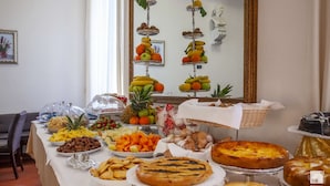 Ein Buffett mit verschiedenen Speisen und ein Spiegel, der Obststände widerspiegelt.