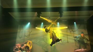 A stage with performers, stage lighting, and a backdrop.