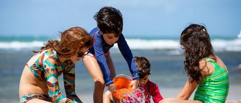 A beach scene with people playing in the sand.