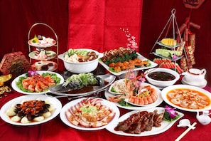 A variety of dishes arranged on a table with a red backdrop.