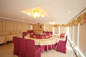 A dining area with round tables, red chairs, and a chandelier. - HiONE Gallery Hotel Taichung (Taichung)