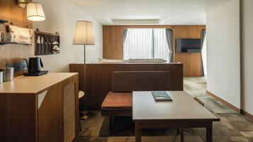 Deluxe driepersoonskamer | Woonruimte | Een 32-inch flatscreentelevisie met kabelzenders en een televisie