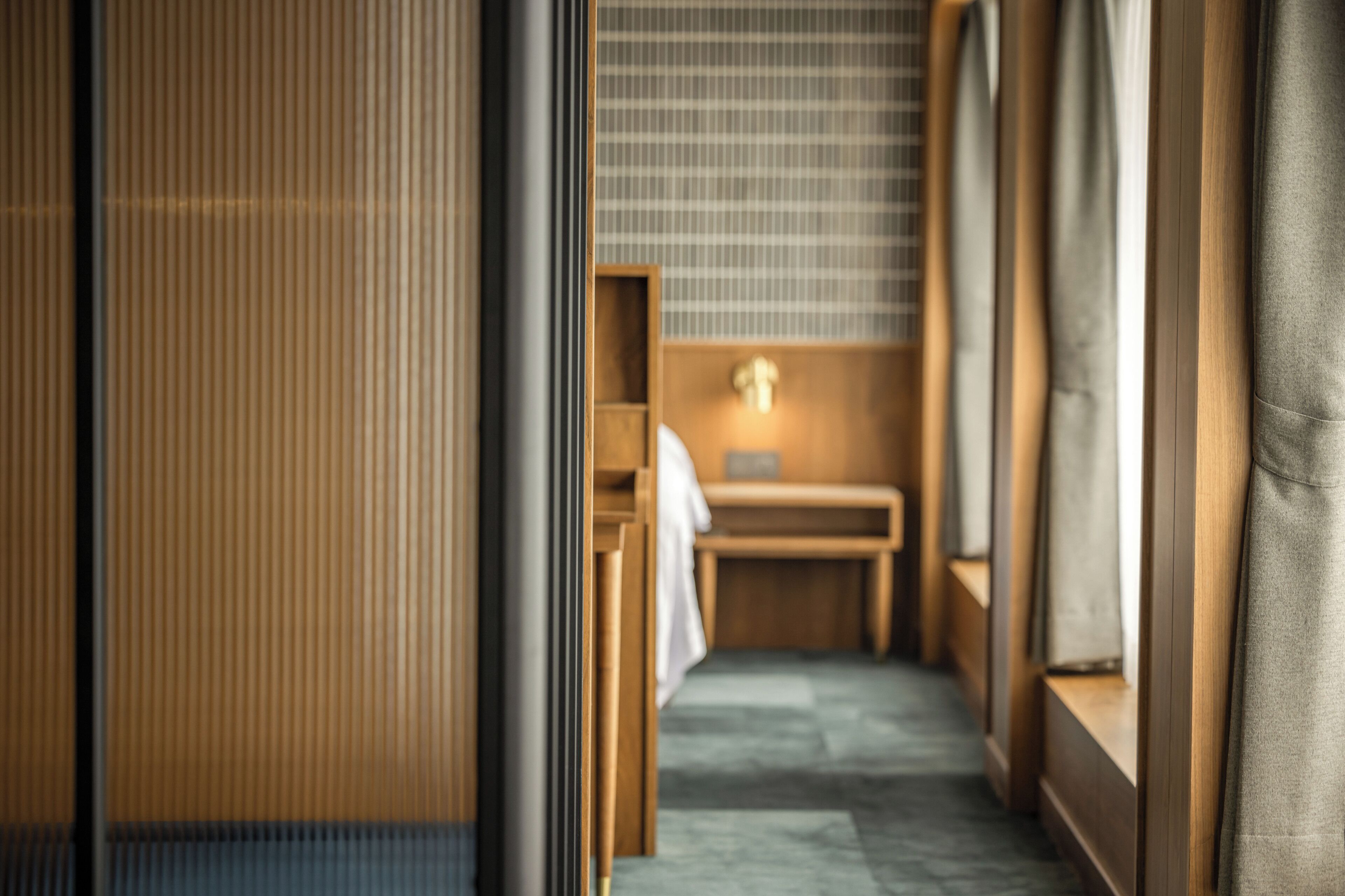 A narrow hallway with wooden paneling and a small wooden bench.