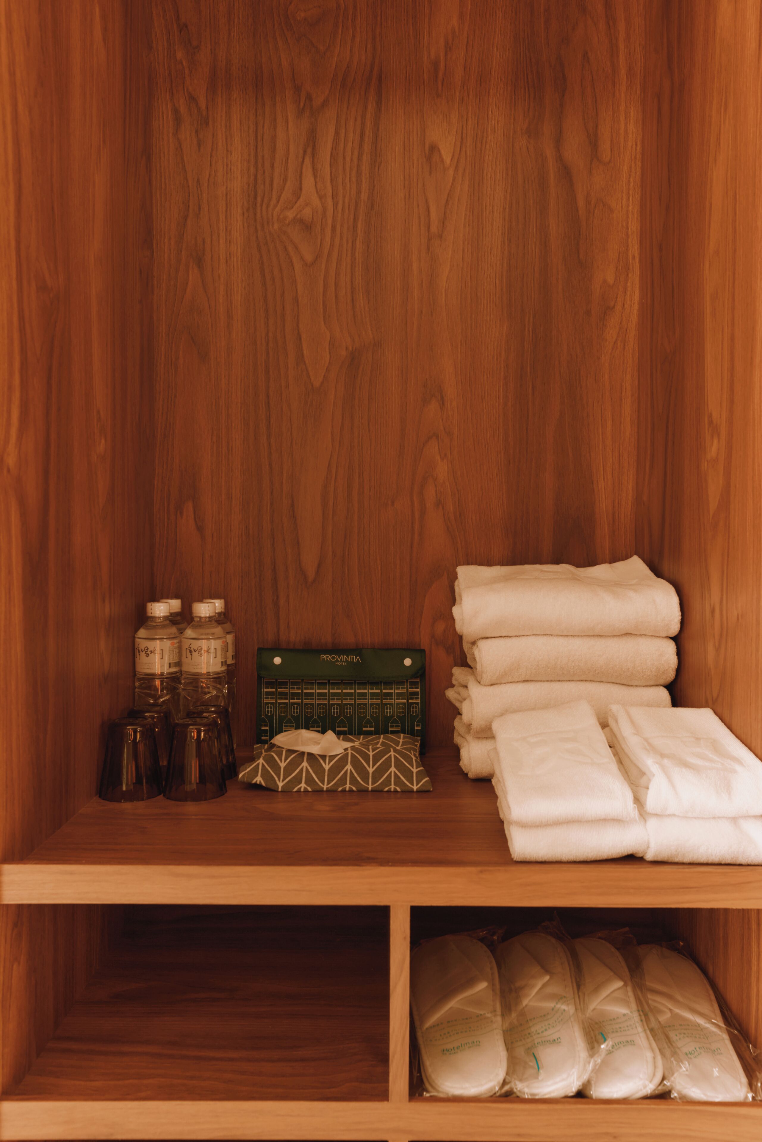 A wooden cabinet with toiletries and folded towels.