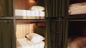 A bunk bed room with curtains, a ceiling light, and a tiled floor.