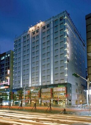 A multi-story hotel with a modern design, featuring a prominent entrance and a series of balconies.