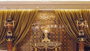 A luxurious lobby with a grand chandelier, ornate golden pillars, and a decorative screen with a clock. - San Want Hotel Taipei (Taipei)