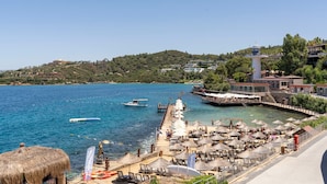 A coastal resort with a pier, beach umbrellas, and lounge chairs. - Blue Dreams Resort-Ultra All Inclusive (Bodrum)