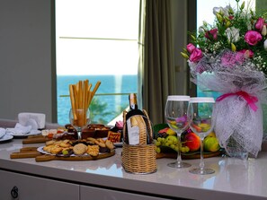 Une table avec une bouteille de champagne, des verres, un panier de biscuits et un bouquet de fleurs.