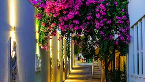 A narrow, well-lit corridor with a row of lights on the left, a wall-mounted clock, and a staircase leading to an upper level. - Blue Dreams Resort-Ultra All Inclusive (Bodrum)