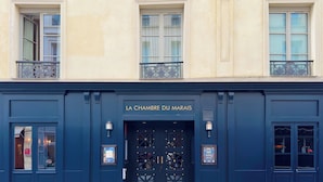 A building facade with a dark blue entrance, two windows with balconies, and a sign reading "LA CHAMBRE DU MARAIS". - La Chambre du Marais (Paris)
