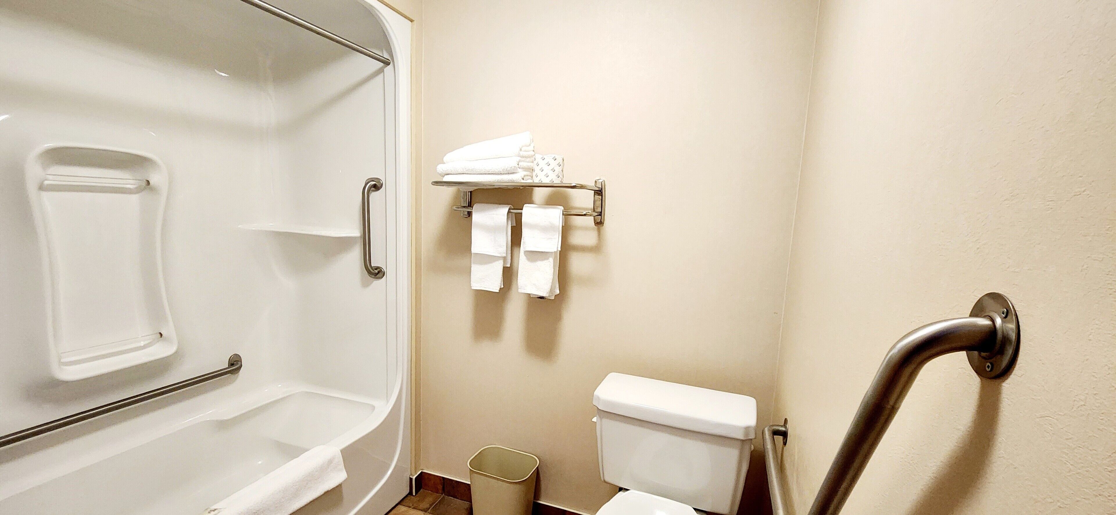 Un bagno con una vasca, un water e uno scaffale con asciugamani.
