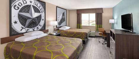 A hotel room with two beds, a television, a desk, and a window with curtains.