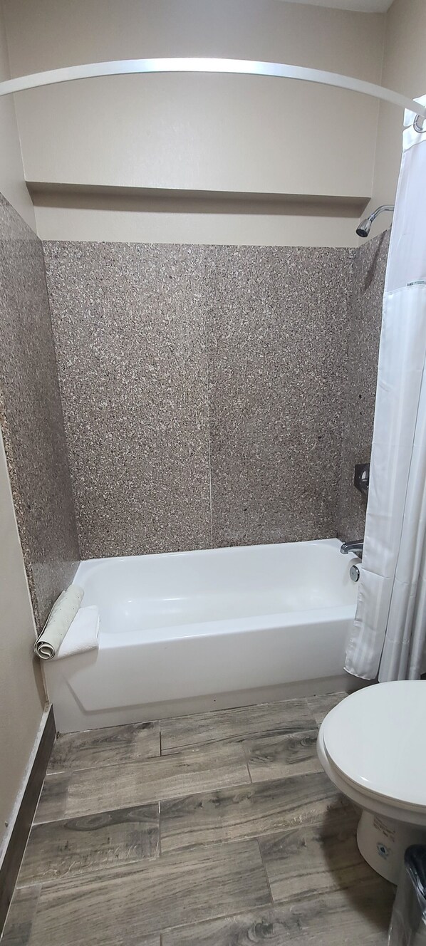 Une salle de bain avec une baignoire, une douche et des toilettes.