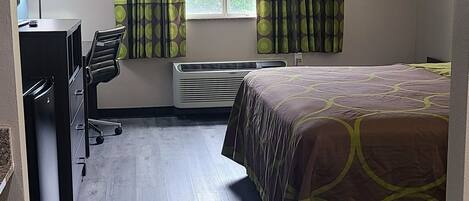 A hotel room with a bed, a desk, and a chair.