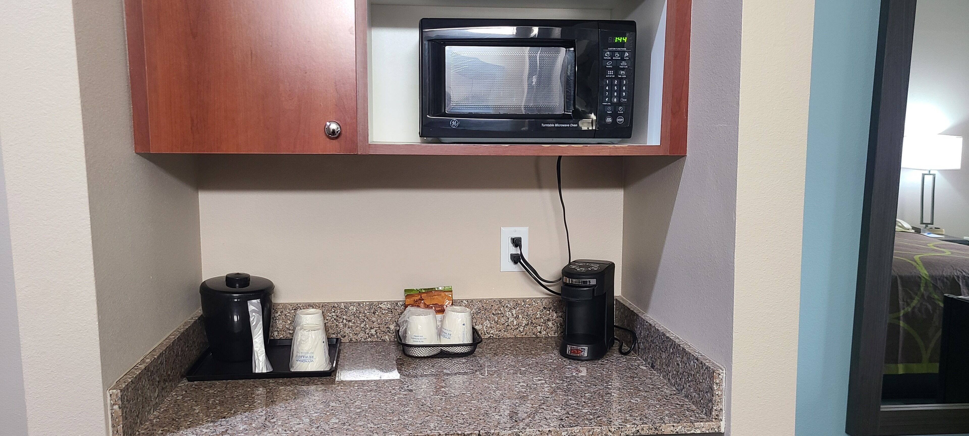 Una kitchenette equipada con microondas, cafetera y tetera.